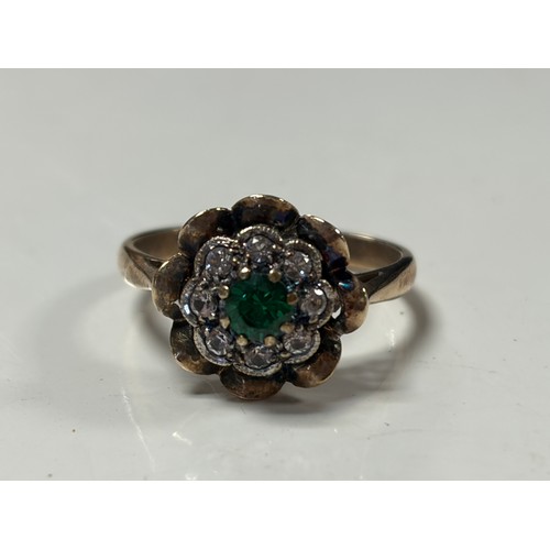 24 - A 9ct gold dress ring, set with a green and clear stone cluster -