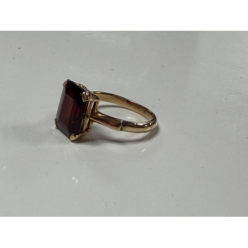 32 - A garnet single stone ring, the rectangular stone claw set in yellow metal mount, stamped 14k and 58... 