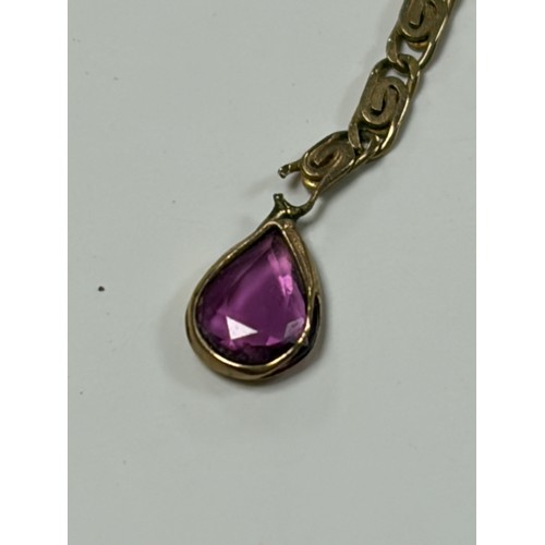 7 - A 9ct gold necklace, with a ruby and diamond cluster suspending two pear shaped rubies and a pair of... 