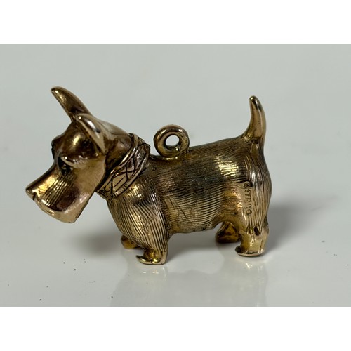 8 - A 9ct gold dog charm, with red paste set eyes -