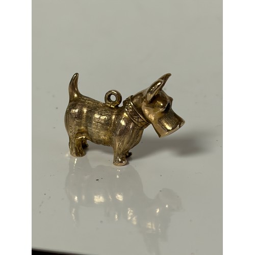8 - A 9ct gold dog charm, with red paste set eyes -