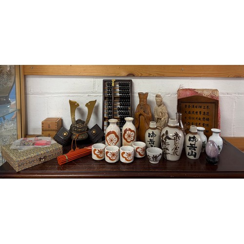 A small mixed lot, to include Chinese abacus, Samurai style small helmet, Saki bottles and cups, etc -