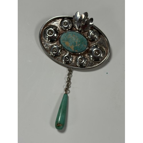67 - An Arts and Crafts silver brooch. the oval panel with blue hardstone panel in textured mount, with d... 