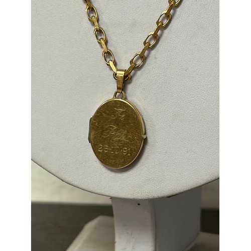 1 - A 9ct gold chain suspending a 9ct oval locket -