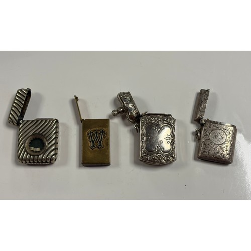 28 - A group of four vestas, to include a silver example and a plated example inset with dice -
