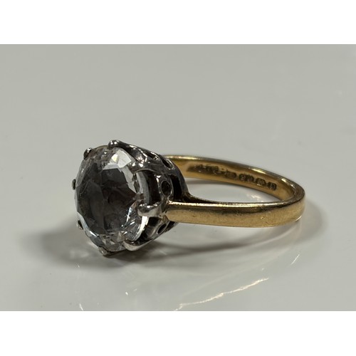 36 - A 22ct gold band, claw set with a large clear paste -