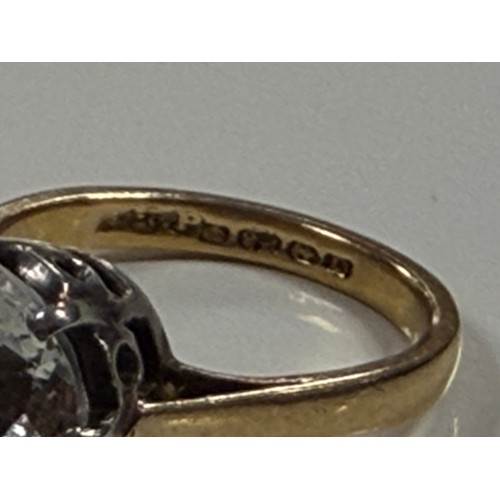 36 - A 22ct gold band, claw set with a large clear paste -