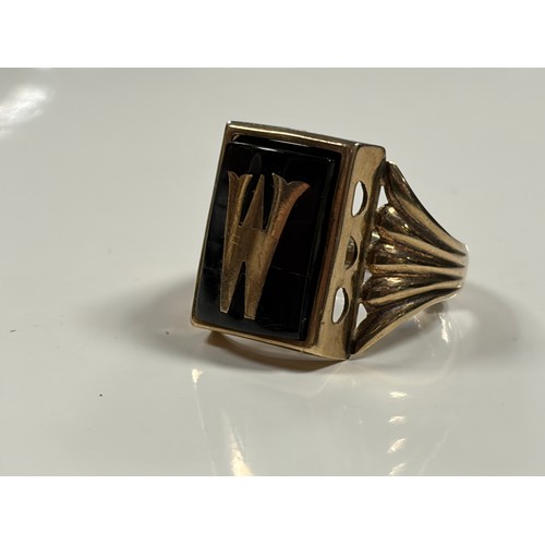 39 - A 9ct gold signet ring, inset with an onyx panel and letter M/W -
