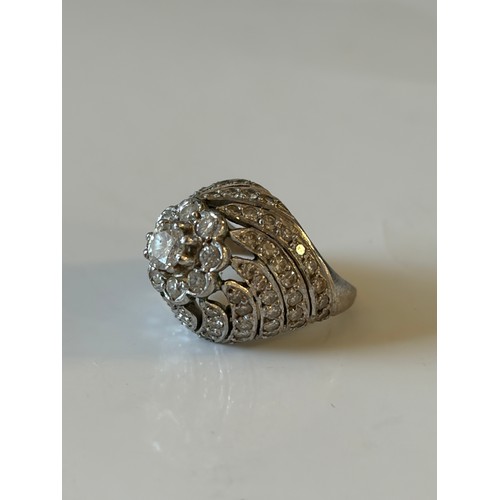 25 - A diamond set dress ring, of tiered flowerhead design, the central cluster to pierced diamond set mo... 