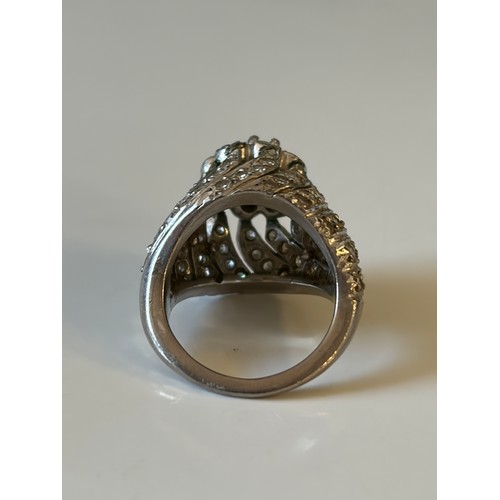 25 - A diamond set dress ring, of tiered flowerhead design, the central cluster to pierced diamond set mo... 
