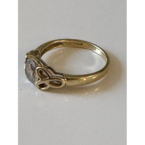 7 - A 14ct gold CZ single stone ring, the circular stone between knotwork shoulders -