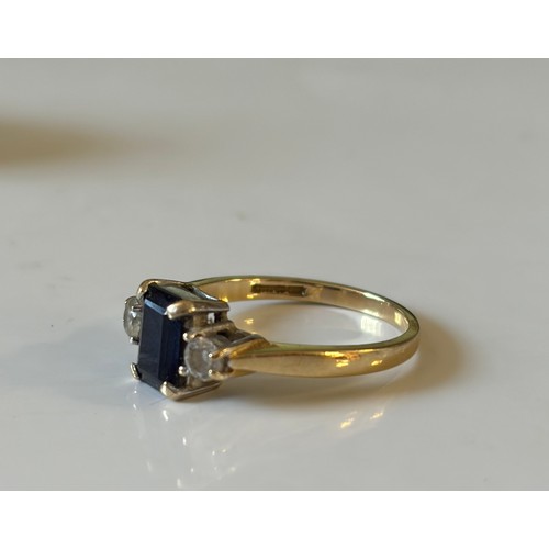11 - A clear and sapphire coloured CZ set three stone ring, set in 14ct gold -