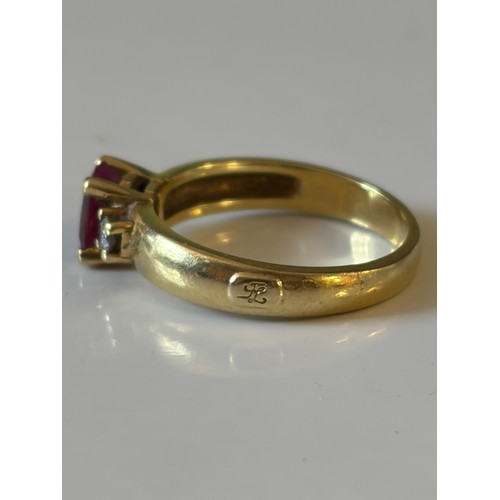15 - A ruby and diamond three stone ring, the central ruby flanked by circular diamonds, in precious yell... 