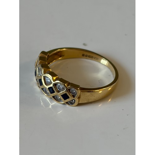 26 - A sapphire and diamond band ring, set with a row of square sapphires between rows of circular diamon... 