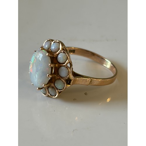 29 - An opal dress ring, of oval cluster design, set in yellow metal mount, stamped 585 -