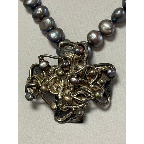 59 - A silver freshwater pearl necklace, the grey tone pearls suspending a silver and pearl cross pendant... 