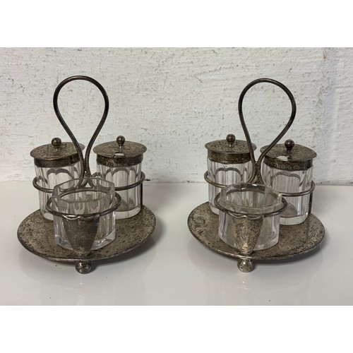 A pair of late Victorian silver cruets, London 1894, each silver frame with loop handle and with three cut glass bottles with silver mounts -