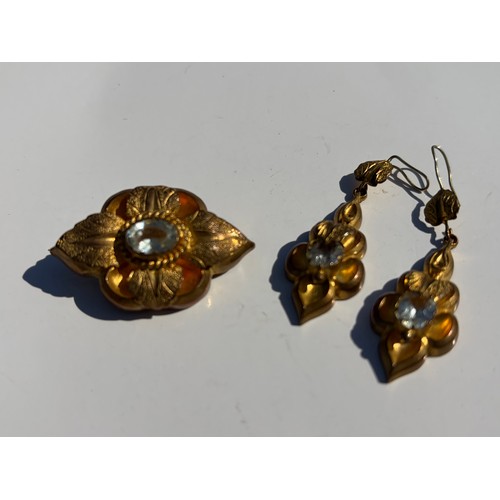 14 - A 19th Century brooch and earring suite, each with textured leaf detail and set with an oval paste -