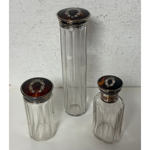 20 - A set of three George V silver and tortoiseshell mounted dressing table bottles, 1918/1919 -