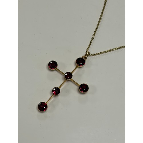 31 - A 9ct gold cross pendant, set with garnets, to rolled gold chain -