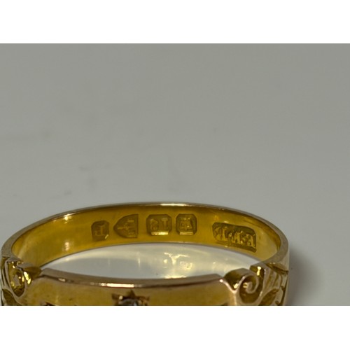 58 - A late Victorian 18ct gold ring, diamond set to the front between scrolled shoulders -