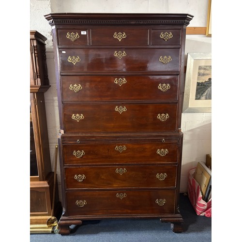 A George III mahogany chest on chest, the stepped dentil cornice over an arrangement of short and long drawers, the base with brushing slide over three long drawers and ogee feet -