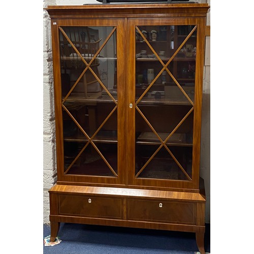 A 19th Century Biedermeier bookcase/display cabinet, with line inlay, the two glazed doors enclosing adjustable shelves, over two base drawers -