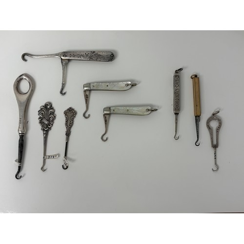 58 - A collection of glove hooks, to include two folding silver and mother-of-pearl examples, a Gorham st... 