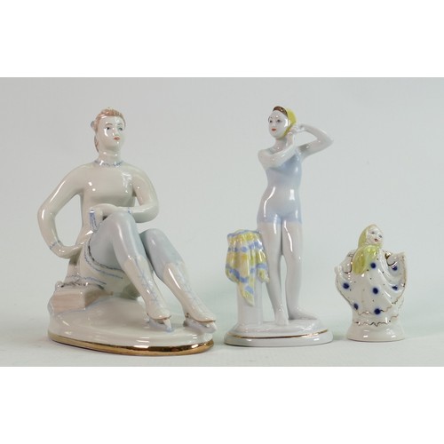 658 - Russian Lomonosov pottery figures of a skater, bather and young child: Height of tallest 18cm. (3)