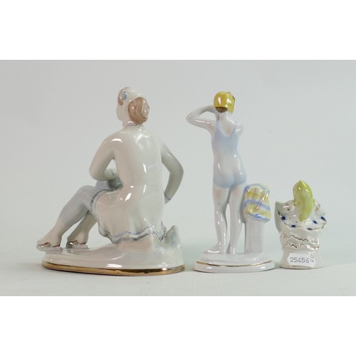 658 - Russian Lomonosov pottery figures of a skater, bather and young child: Height of tallest 18cm. (3)