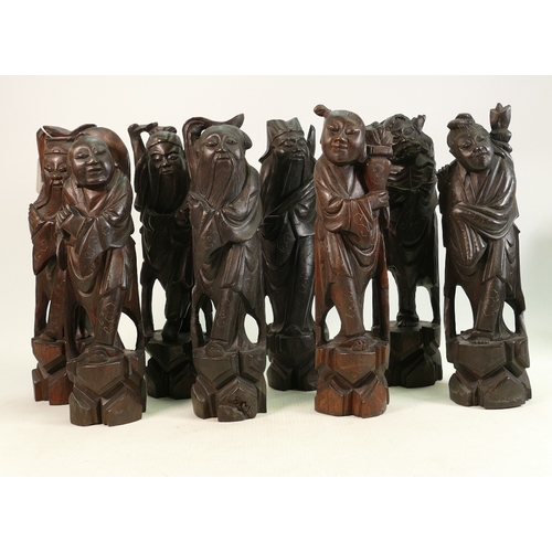 99 - Eight carved wooden Chinese figures of Immortals: All inlaid with pewter or similar metal.  Some min... 