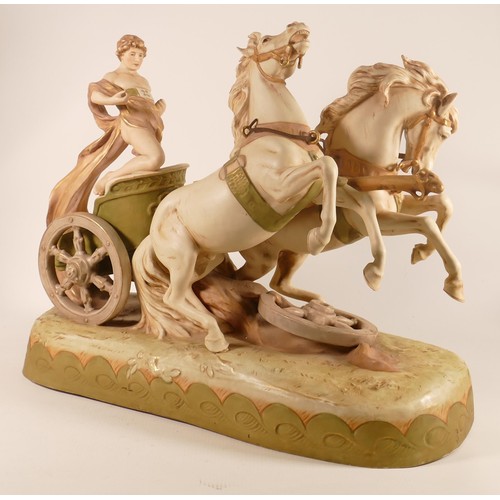 697 - A Royal Dux porcelain figure group, early 20th century, modelled as a classical youth riding a chari... 