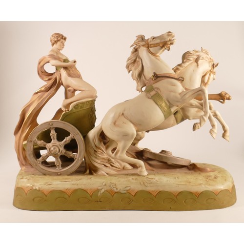 697 - A Royal Dux porcelain figure group, early 20th century, modelled as a classical youth riding a chari... 