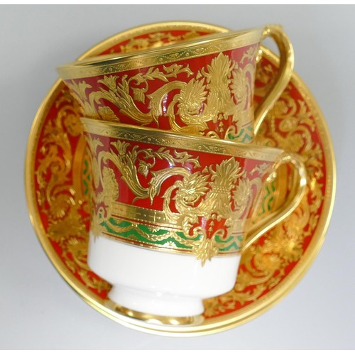 1009 - De Lamerie Fine Bone China heavily gilded Red/ Green Empress patterned cup / saucer sets, specially ... 