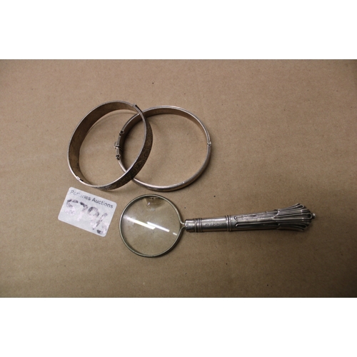 579 - Two hallmarked sterling silver bangles together with a silver handled magnifying glass, weight of th... 