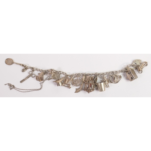 681 - Silver charm bracelet with 19 assorted charms, 43.3g.