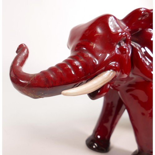 386 - Royal Doulton large Flambe model of an elephant with white tusks, h.28cm, a/f. End of trunk re-stuck... 