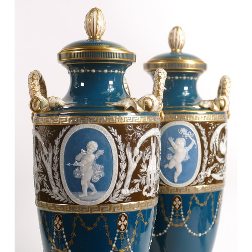 884 - A stunning pair of Minton two handled Pate-sur-Pate vase & covers, gilded and decorated with cupids ... 