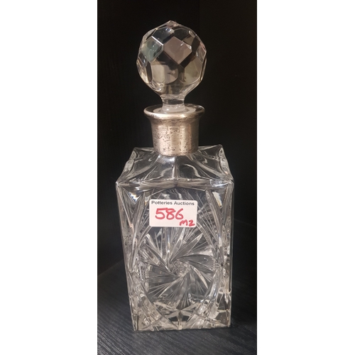 586 - A crystal decanter with sterling silver collar