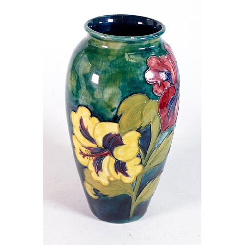 484 - Large Moorcroft vase in the Hibiscus pattern, 26cm high. Original Queen Mary paper label to base. Ti... 