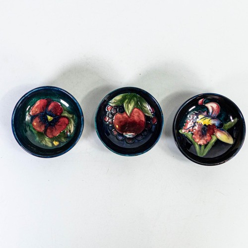 554 - Three small Moorcroft footed bowls in Pomegranate, Orchid and Pansy designs, d.7.5cm. (3)