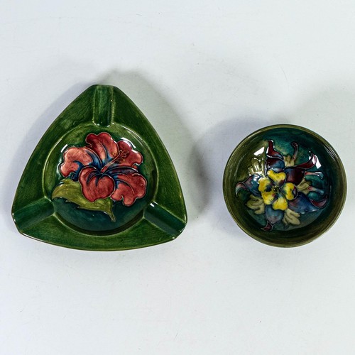 557 - Two small Moorcroft footed dishes in Clematis and Hibiscus designs, largest d.13cm. (2)