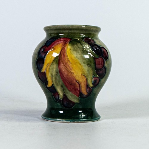 560 - Moorcroft small vase decorated in the Leaf & Berry design, h.8.5cm.