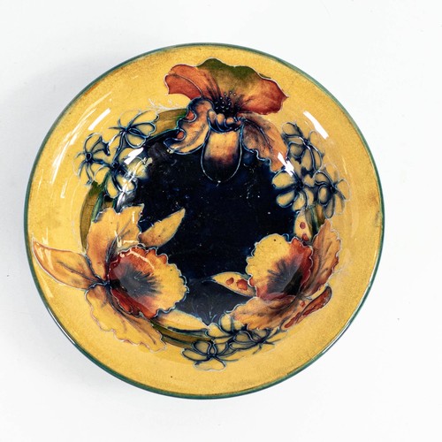 570 - William Moorcroft footed bowl with Orchid design on ochre ground c.1930, hairline crack to rim, craz... 