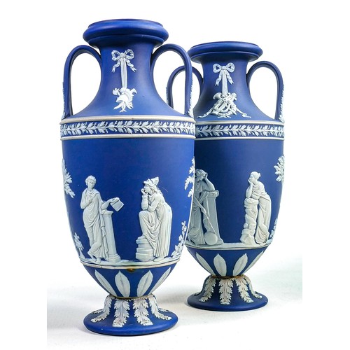 622 - Pair of Wedgwood dark blue dipped Jasperware two handled urns, both decorated all around with classi... 