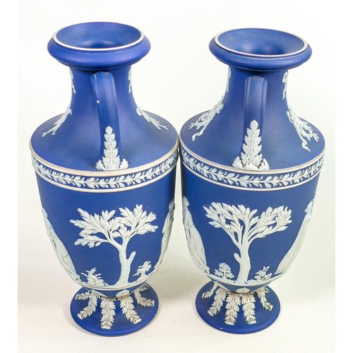 622 - Pair of Wedgwood dark blue dipped Jasperware two handled urns, both decorated all around with classi... 