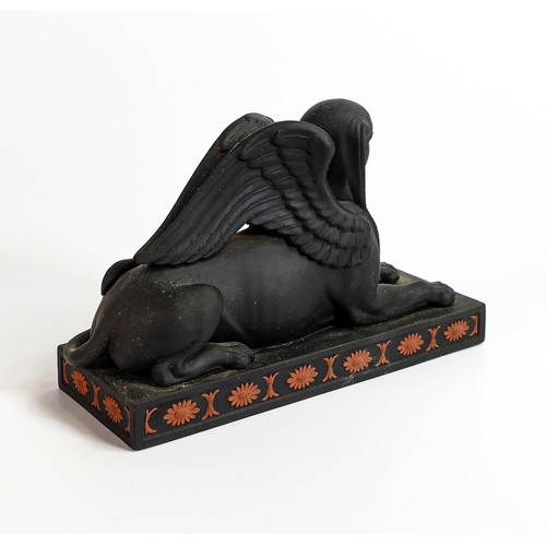 667 - Wedgwood black Basalt model of a Couchant Sphinx with terracotta Egyptian designs, h.10 x L16cm.