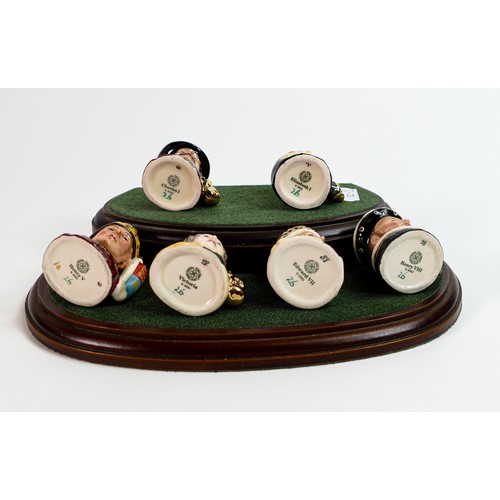 1308 - Royal Doulton set of tiny character jugs Kings and Queens of England, on wooden stand. (7)