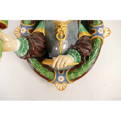 1606 - Minton Majolica wall sconce, in the form of a Renaissance man holding a torch, set in oval laurel wr... 