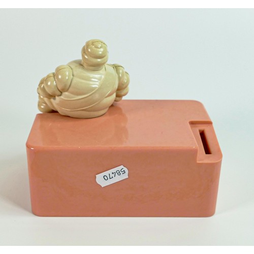 2240 - Michelin bakelite employees money box, modelled as a seated Mr Bibendum to pink base, h.13cm x w.15c... 